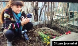 Fotograf Umida Ahmedova rassom qabri ustida qur’on tilovat qilmoqda